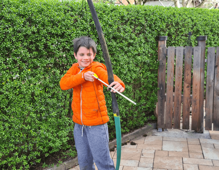 Junge der Pfeil und Bogen hält